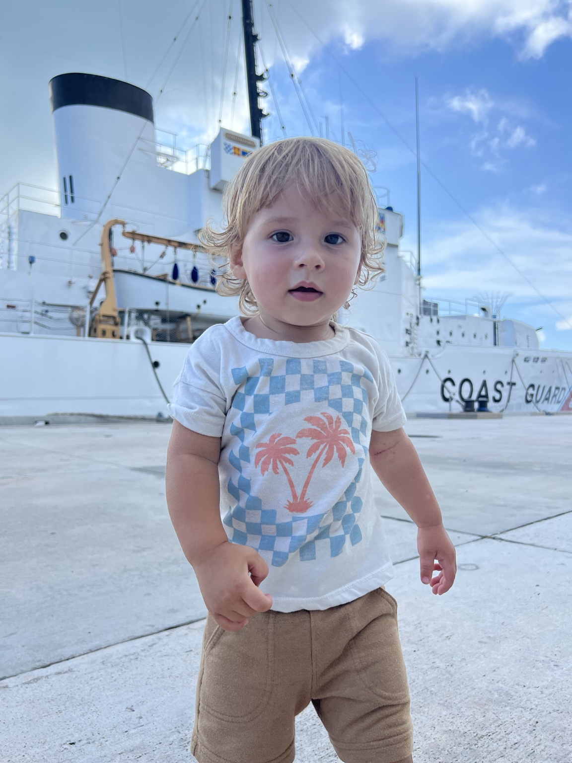 Charlie standing in front of a Coast Guard ship